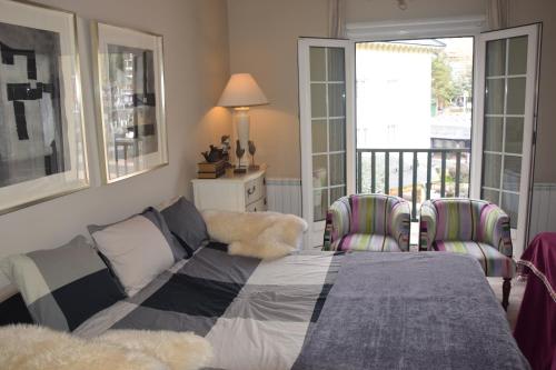 シエラネバダにあるIMEDA ESTUDIO DORNAJOのベッドルーム1室(ベッド1台、椅子2脚、バルコニー付)