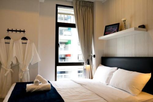 a bedroom with a large bed and a window at The Urban Age DeLuxe in Bangkok