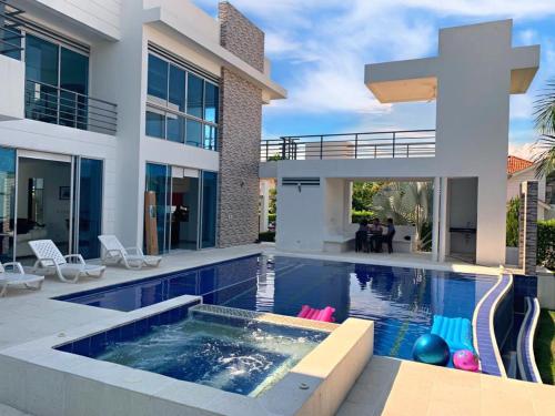a large house with a swimming pool in front of it at Hermosa Villa de Descanso in Carmen de Apicalá