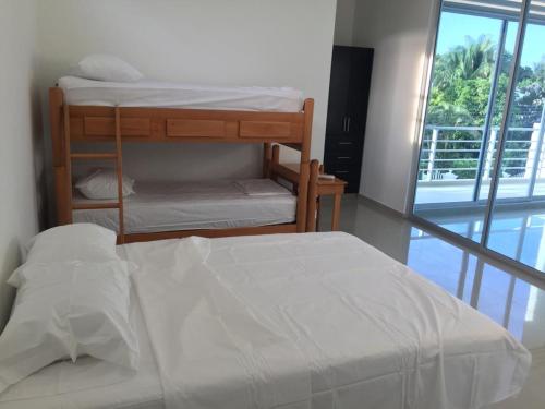 a bedroom with two bunk beds and a window at Hermosa Villa de Descanso in Carmen de Apicalá