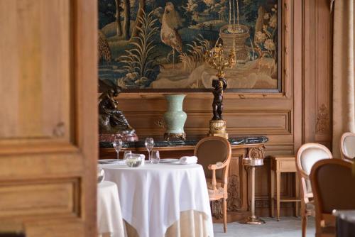 a dining room table with a vase of flowers on it at Domaine les Crayères in Reims