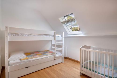 - une chambre blanche avec 2 lits superposés et une fenêtre dans l'établissement Grande maison avec piscine à Pornichet, à Pornichet