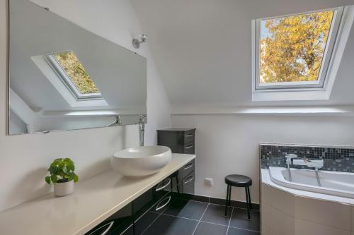 une salle de bain avec un lavabo et une baignoire dans l'établissement Grande maison avec piscine à Pornichet, à Pornichet