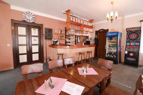 a restaurant with tables and chairs and a bar at Penzion Paseky U Zapadlych vlastencu in Paseky nad Jizerou