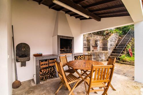 a dining room with a table and chairs and a stove at Casa do Pinheiro with shared swimming pool in São Vicente Ferreira