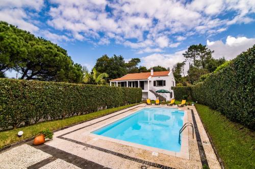 a swimming pool in the yard of a house at Casa do Pinheiro with shared swimming pool in São Vicente Ferreira