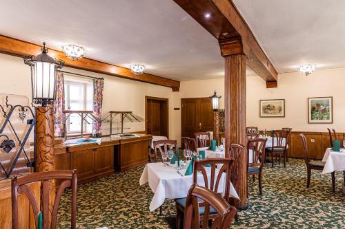 ein Restaurant mit Tischen und Stühlen in einem Zimmer in der Unterkunft Churfuerstliche Waldschaenke in Moritzburg
