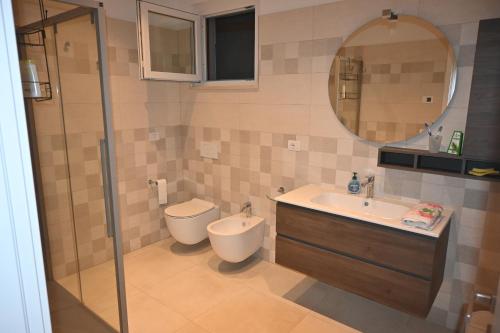 a bathroom with a toilet and a sink and a shower at Villa Maria in San Feliciano