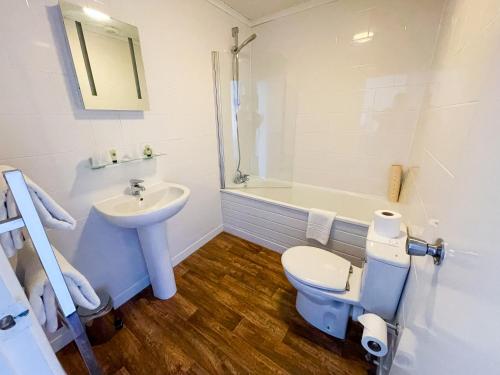 a bathroom with a sink and a toilet and a tub at The Star and Garter Hotel in Andover