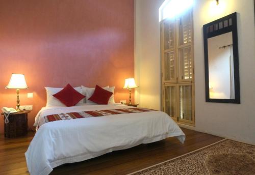 a bedroom with a large bed and a large mirror at Spices Hotel in George Town