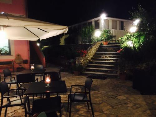 a restaurant with tables and chairs and stairs at night at Agriturismo Petrara in Simeri