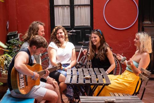 un grupo de personas sentadas alrededor de una mesa tocando música en Onefam Centro, en Sevilla