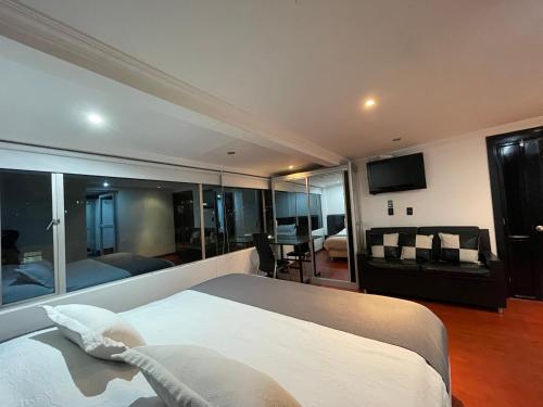 - une chambre avec un grand lit et un salon dans l'établissement Hotel Ejecutivo Embajada, à Bogotá