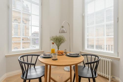 a dining room with a wooden table and chairs at Museum Apartments in Edinburgh