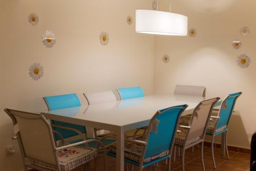 a dining room with a white table and chairs at Finca Olivar de Castilla - Sun&Colors in Segovia