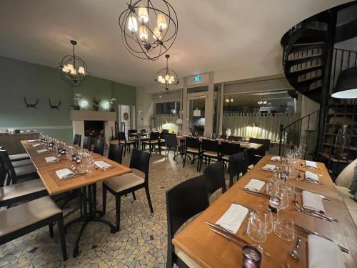 uma sala de jantar com mesas e cadeiras de madeira em Auberge du Chasseur em Grosrouvre