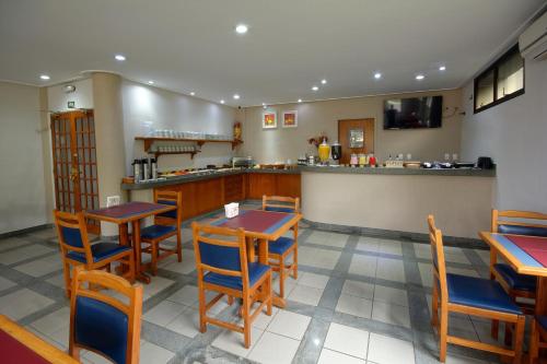 a restaurant with wooden tables and chairs and a counter at Fênix Hotel Limeira in Limeira