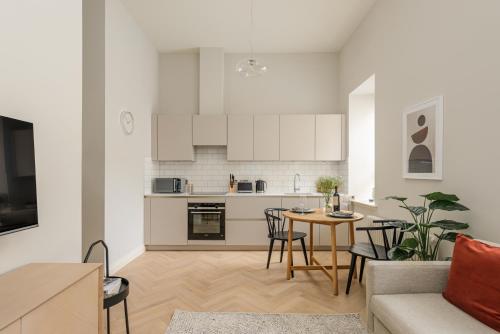 a kitchen and living room with a table and chairs at Museum Apartments in Edinburgh