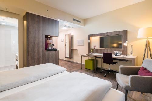 a hotel room with a bed and a desk at Best Western Hotel Airport Frankfurt in Frankfurt/Main