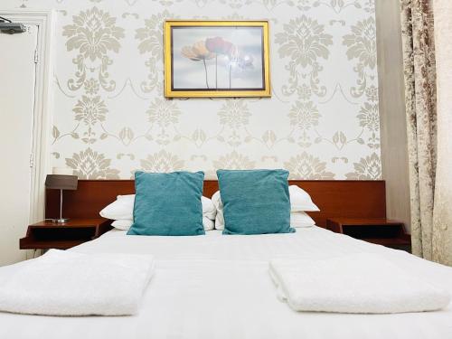 a bedroom with a white bed with blue pillows at Trivelles Park Hotel in Preston