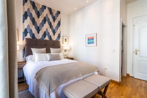 a bedroom with a large bed with a large headboard at tuGuest Isabel la Catolica Apartment in Granada