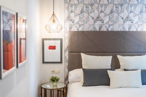 a bedroom with a bed with a headboard and a table at tuGuest Isabel la Catolica Apartment in Granada