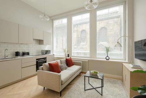 a living room with a couch and a kitchen at Museum Apartments in Edinburgh