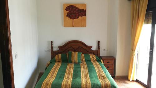 ein Schlafzimmer mit einem Bett mit einer grünen und gelben Decke in der Unterkunft Casa Las Truchas in El Bosque