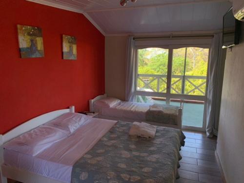 a bedroom with two beds and a large window at Hotel Mirador del Dayman in Termas del Daymán
