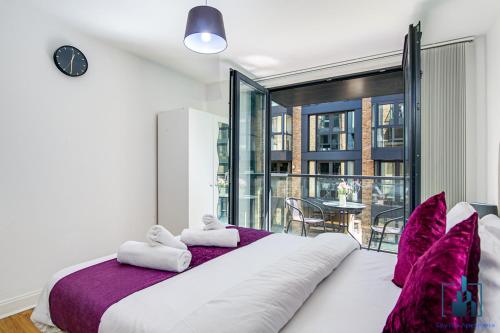 a bedroom with a large white bed with purple pillows at City View Apartments in Birmingham