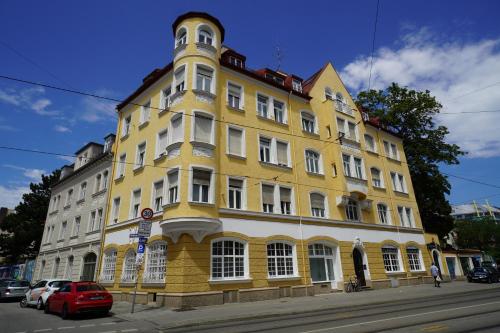 un edificio blanco y amarillo en una calle de la ciudad en HOMELY STAY Studio 1, en Múnich