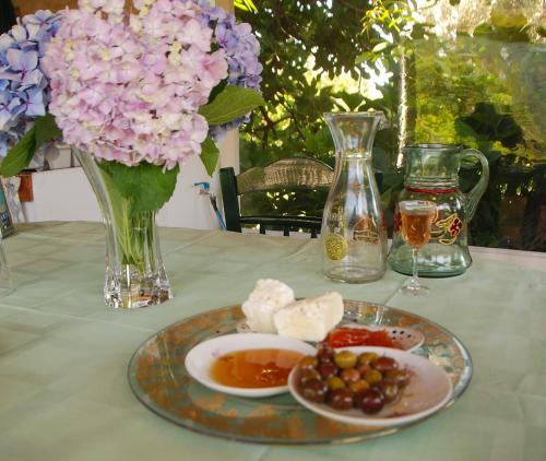 a table with a plate of food and a vase with flowers at Alekas Studios in Therma