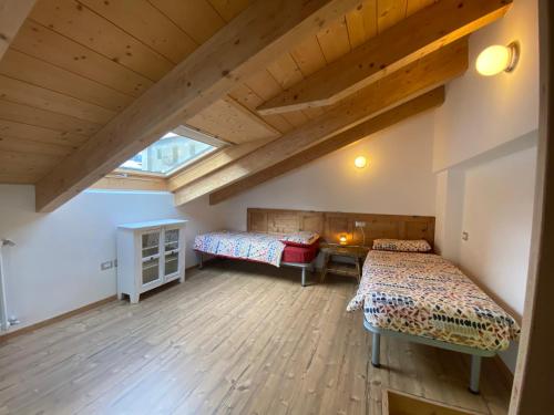 a attic room with two beds and a desk at Chalet dei Reparti Bormio in Bormio