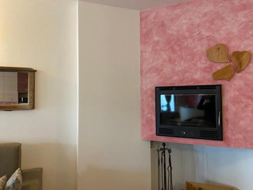 a tv on a wall in a living room at Chalet dei Reparti Bormio in Bormio