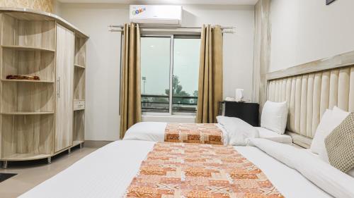 a bedroom with two beds and a couch at Hotel Crown Inn Multan in Multan