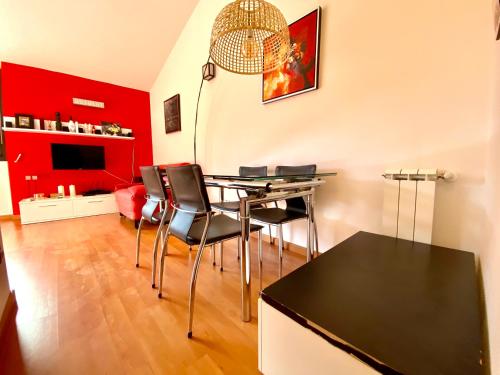 een eetkamer met een tafel en stoelen en een rode muur bij Orquídea 7.3 in El Tarter