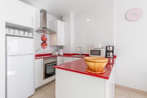 a kitchen with white cabinets and a bowl on a red counter at Altea Villa Buraux , Apartamento con vistas al mar & parking en el corazón del casco viejo de Altea in Altea