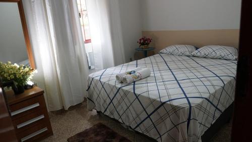 a bedroom with a bed with two towels on it at Pousada e Hospedaria Regina in Cachoeiro de Itapemirim