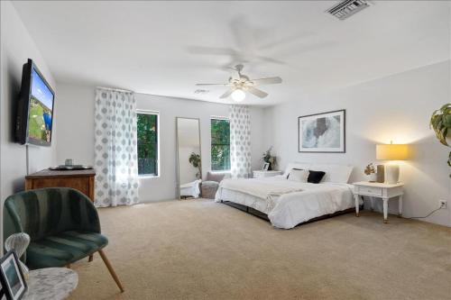 - une chambre avec un lit, une télévision et une chaise dans l'établissement 5 Bedroom 4 Bath Boutique Home PREMIUM LOCATION + heated pool option, à Glendale