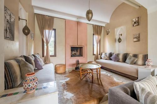a living room with a couch and a table at Villa Selma avec piscine chauffée in Marrakesh