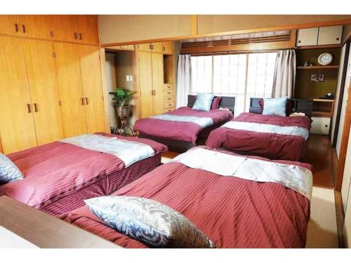 a room with four beds with red sheets at THE TORII - Vacation STAY 68438v in Kumamoto