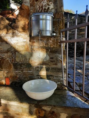 a bowl on the side of a wall with a bucket at ΑΡΧΟΝΤΙΚΟ ΑΡΤΕΜΙΣ-Villa Artemis since 1871 in Agios Georgios Nilias