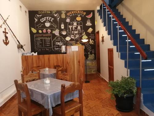 un restaurante con una mesa y una pizarra en la pared en Hostal La Casa de Luis, en Puerto Baquerizo Moreno