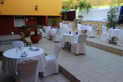 a group of tables with white tables and chairs at Altamont West Hotel in Montego Bay