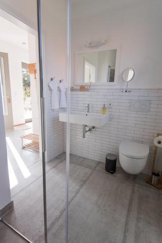 a white bathroom with a sink and a toilet at Viereinhalb Eichen - Ferienwohnung am Niederrhein in Goch