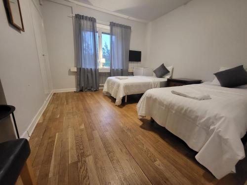 1 dormitorio con 2 camas y suelo de madera en IzKaMaGe Hotel 2, en Västerås