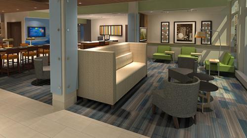 a lobby of a hotel with tables and chairs at Holiday Inn Express & Suites - Canton by IHG in Canton