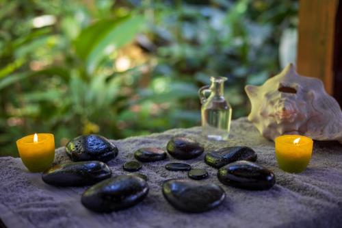 a table with two candles and a group of rocks at Namuwoki Lodge in Puerto Viejo