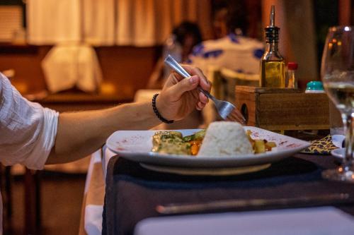 a person sitting at a table with a plate of food at Namuwoki Lodge in Puerto Viejo