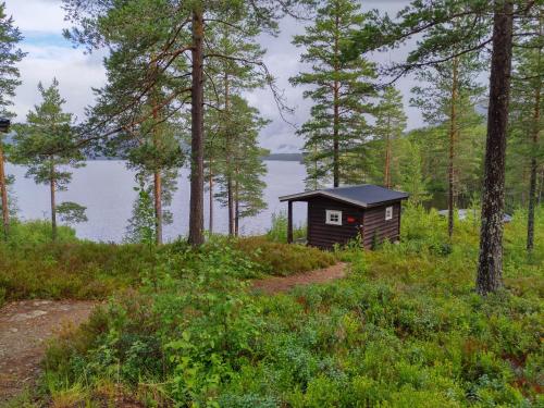 una pequeña cabaña en el bosque junto a un cuerpo de agua en Telemark Camping, en Hauggrend